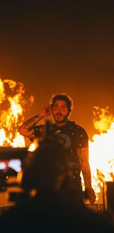 a man standing in front of a fire