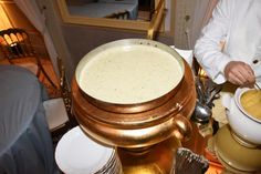 a man in a chef's coat is preparing food on a gold platter