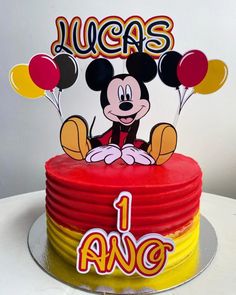 a mickey mouse birthday cake with balloons and the name lucas on it's top