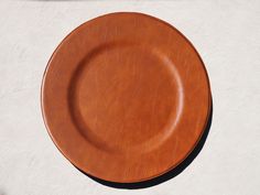 a brown plate sitting on top of a white wall