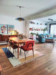 a living room with wooden floors and colorful furniture in the center, along with an area rug on the floor