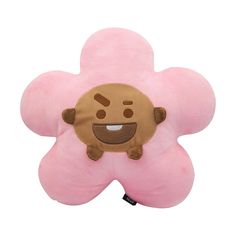 a pink flower shaped pillow with a smiling face