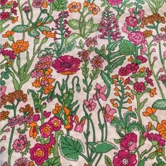 an image of colorful flowers and plants on white fabric with pink, red, orange, green leaves