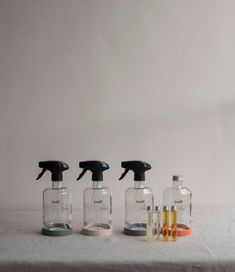 three bottles with different types of cleaners on top of a white countertop next to each other