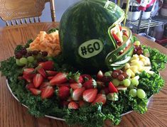 a watermelon helmet sitting on top of a platter filled with fruit