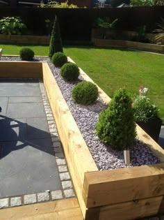 an outdoor garden with wooden planters and gravel