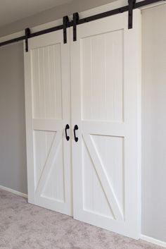 an empty room with two sliding doors and carpeted flooring in the foreground