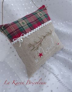 a christmas pillow hanging from the side of a bed