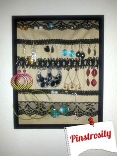 there is a wall hanging with jewelry on it