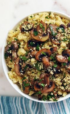 a white bowl filled with mushrooms and couscous