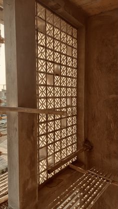 an unfinished room with wooden slats on the wall and floor, in front of a window