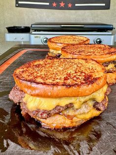 three grilled cheese sandwiches sitting on top of a counter next to an open oven