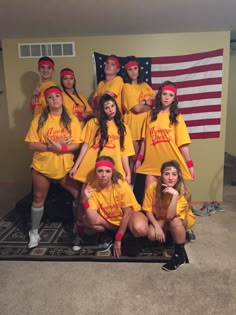 a group of young women in yellow shirts posing for a photo with an american flag behind them