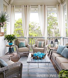 a living room with two couches and chairs on the front porch, covered in white curtains