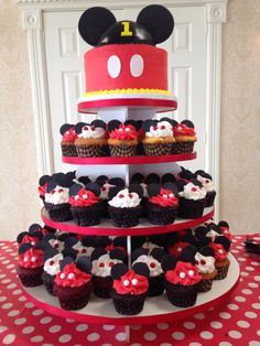 a mickey mouse cake and cupcakes on a table