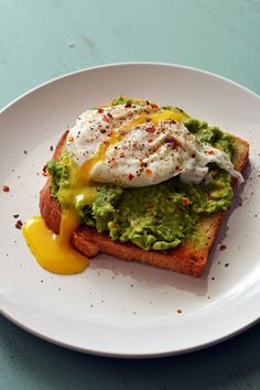 an open face sandwich with guacamole and poached egg on it