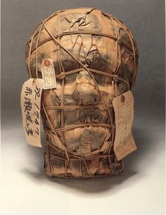 an old mask with writing on it and tags attached to the front of its face