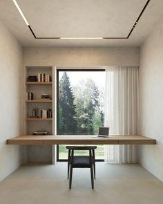 a desk with a laptop on it in front of a window and bookshelves