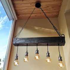 a wooden beam with five light bulbs hanging from it