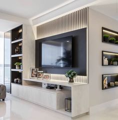 a living room with a large television on the wall and shelves in front of it