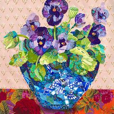 a blue vase filled with purple flowers on top of a colorful tablecloth covered table