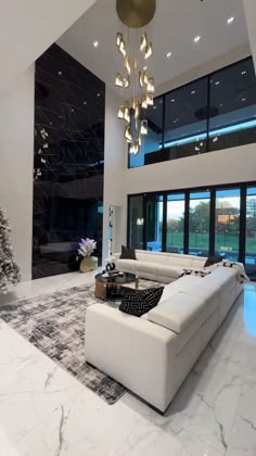 a modern living room with white furniture and large windowed area in the back ground