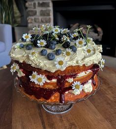 a cake on a table with flowers and berries