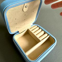 an open blue case with four compartments on the inside and one in the other hand