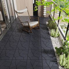 a rocking chair sitting on top of a patio next to plants