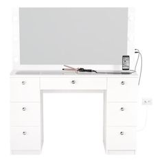 a white desk with a cell phone on top of it and a mirror above it