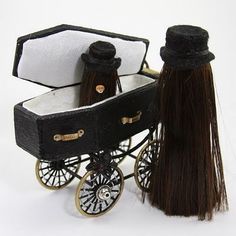 a doll's black and white carriage with long brown hair