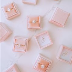 wedding rings in pink velvet boxes on a marble table with monogrammed numbers and initials