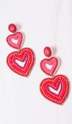 "This double heart earring is charming! It has two open heart drops with shades of red beading. It has a matching beaded post and is felt covered on the back. Dimensions: 3.5\" long" Cheap Red Heart Bead Earrings, Red Heart Beads Dangle Earrings, Heart Charm Beaded Earrings For Valentine's Day, Red Double Heart Earrings With Heart Beads, Red Heart Beads Earrings For Valentine's Day, Heart Shaped Beaded Earrings For Valentine's Day, Heart-shaped Beaded Earrings For Valentine's Day, Valentine's Day Beaded Earrings With Heart Charm, Red Dangle Earrings With Heart Beads