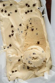 an ice cream sundae with chocolate chip cookies on top in a paper wrapper