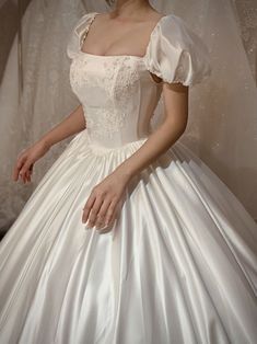 a woman in a white wedding dress is posing for the camera with her hands on her hips