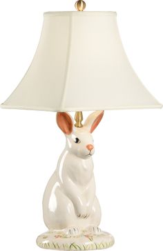 a white rabbit lamp sitting on top of a table next to a lampshade