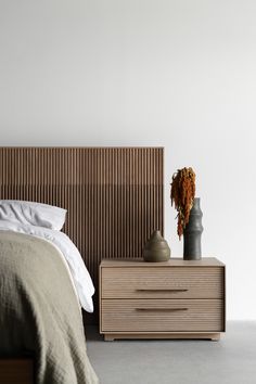 a bed with a wooden headboard and nightstand next to it