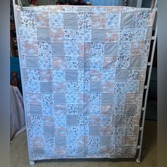 a blue and white quilt hanging from a clothes rack