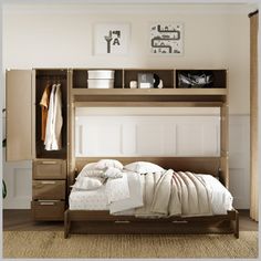 a bed with white sheets and blankets in a room next to an open cabinet door