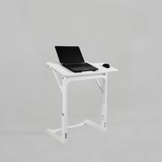 a laptop computer sitting on top of a white desk