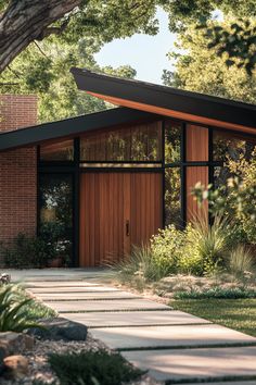 a small house with a large tree in the front yard and walkway leading up to it