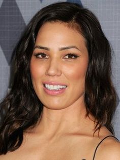 a close up of a person with long hair and brown eyeshadow wearing a black dress