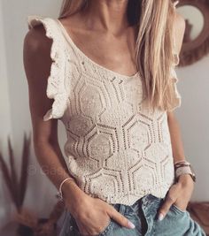 a woman with long blonde hair wearing jeans and a white top is posing for the camera