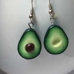 an avocado shaped earrings is hanging from silver hooks