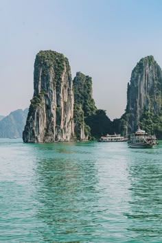 a boat is in the water next to some large rocks and small island like structures