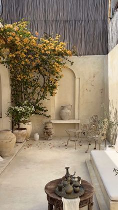 an outdoor room with potted plants and vases