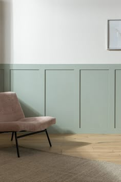 a chair sitting on top of a hard wood floor next to a green painted wall