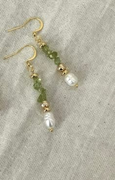 Statement Peridot & Pearl Cascade Dangle Earrings  Designed to make a statement, these bold dangle earrings bring elegance to any outfit. Handmade with genuine peridot stones, freshwater pearls, and gold-plated accents, they're perfect for those moments when you want to feel extra special. Whether it's a wedding, a holiday party, or a romantic evening out, these earrings will turn heads and add a touch of sophistication to your look.                               From Our Timeless Peridot & Pearl Collection                                                  Crystal Cascade Earrings * Product   Detail * - Crystal quartz, green glass bead, freshwater pearl - Clasp: Fishhooks - Gold-plated  - Style: Vintage-inspired, holiday-ready elegance - Tarnish - Resistance - Handmade and made to order - L Gold Homemade Jewelry, Vintage Dainty Jewelry, Homemade Dangle Earrings, Homemade Gold Earrings, Beads Earrings Design, Pearl Earring Ideas, Earring With Beads, Gold Jewelry With Pearls, Beaded Pearl Earrings