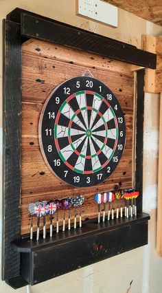 a dart board mounted to the side of a wall with darts on it and pins in front of it