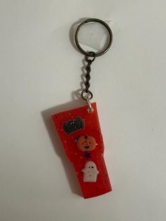 a keychain with a piece of red material on it's side and a cartoon character in the middle